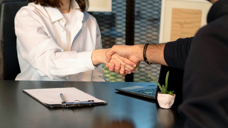 Interviewer shaking hands with job candidate.