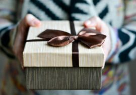 Hands holding a gift with a bow on it